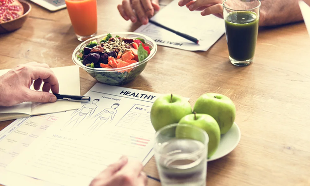 Alimentos e copos de suco em cima da mesa com papéis